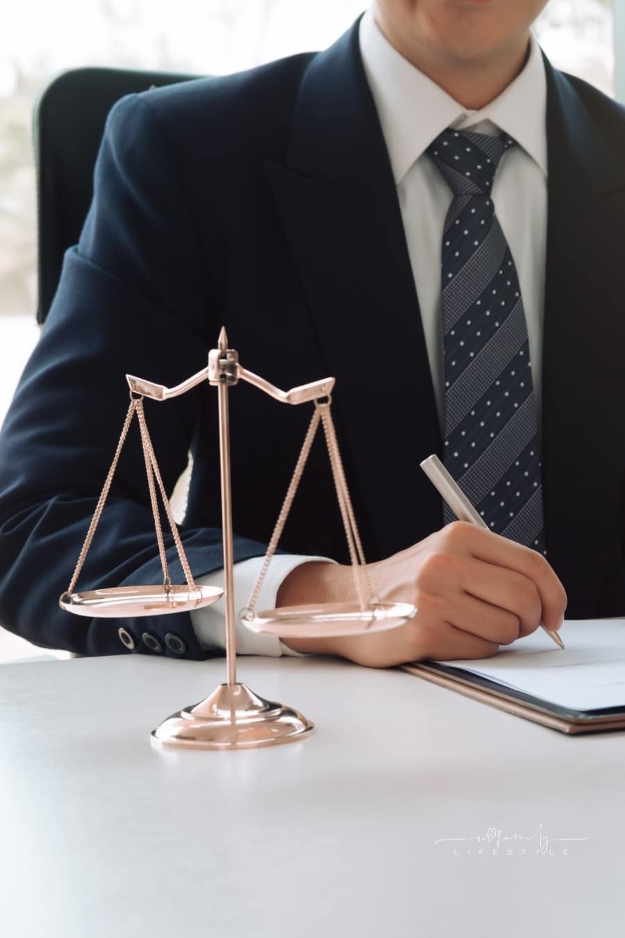 Justice and Law Concept. male lawyer holding pen over contracts with justice scale in forefront