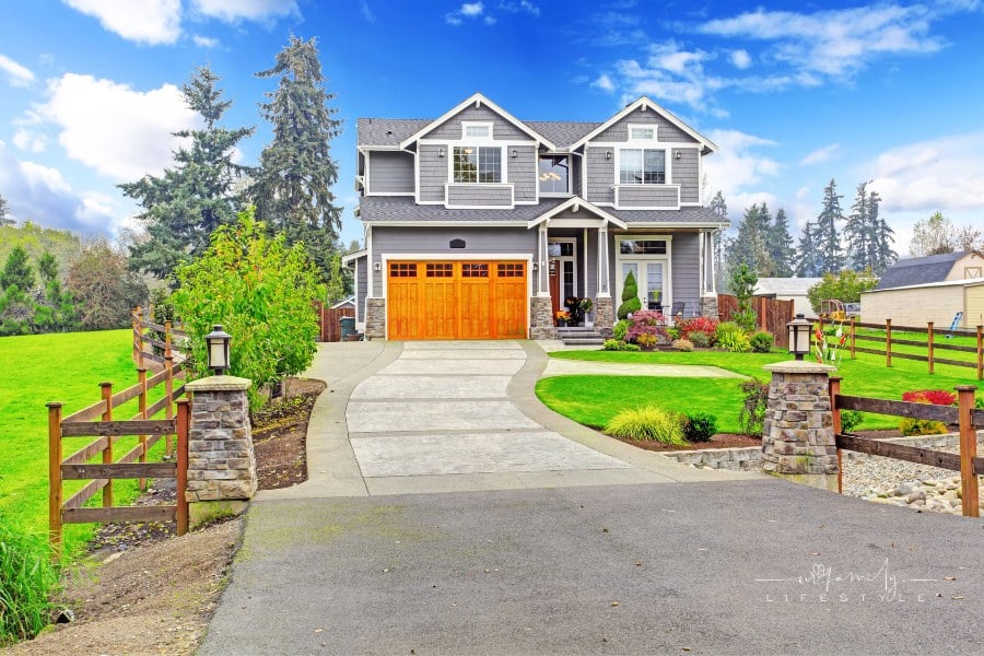 House exterior with column porch, wooden garage doors, and attractive curb appeal