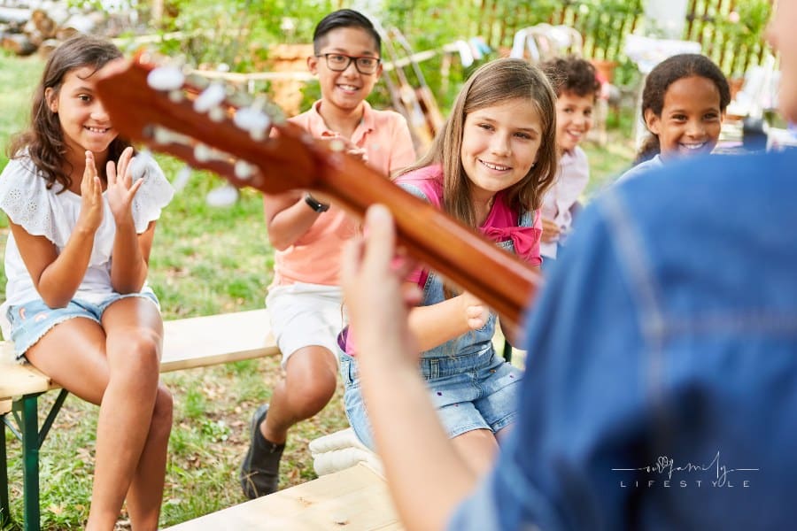 Group of Children watching Family Talent Show in backyard
