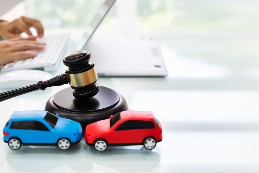 car accident attorney concept with gavel and plastic cars