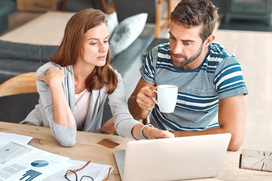 couple working on income taxes at laptop