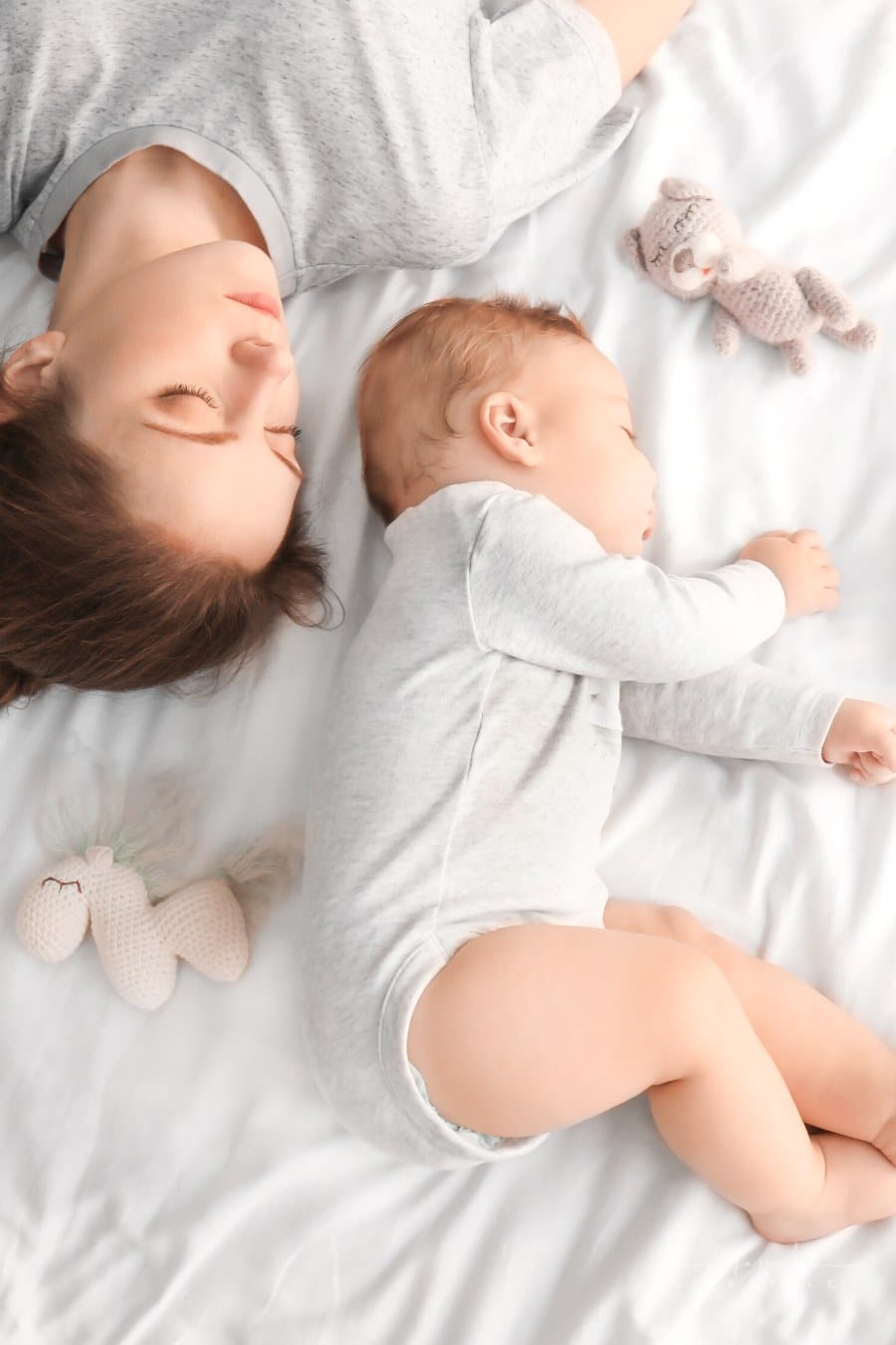 mom and baby napping together on bed