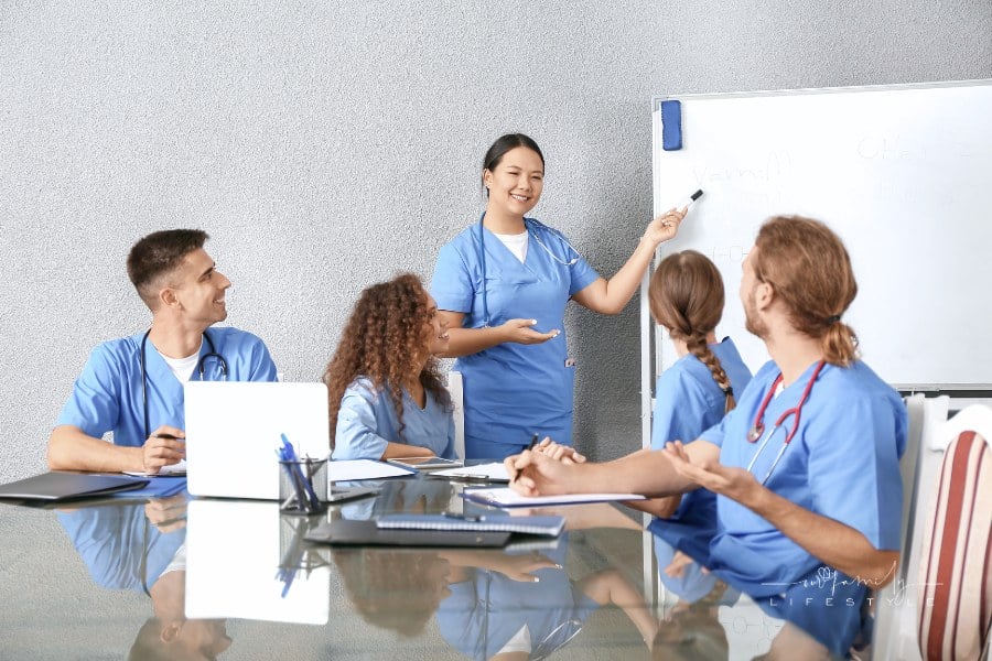 group of nurses in blue scrubs attending a meeting