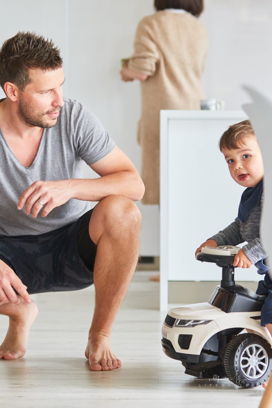 Father and child with push car as a children's vehicle at home in the living room