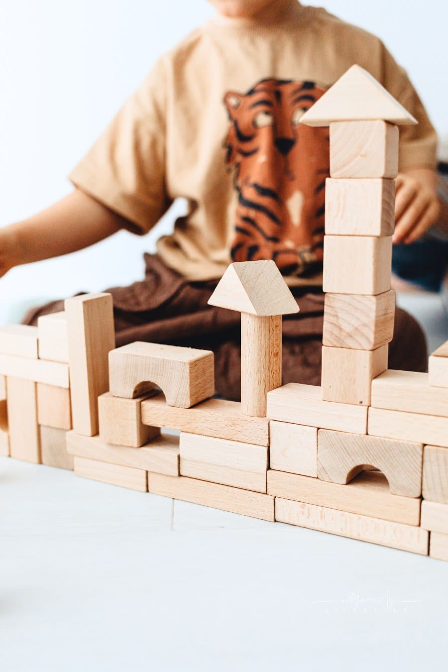 Stacked Wooden Building Blocks Near a Kid