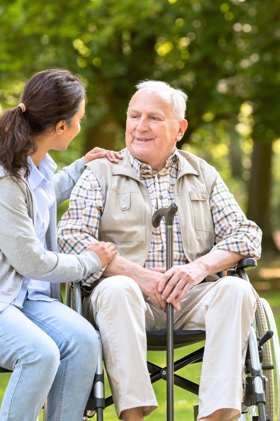 Senior man with wheelchair and caregiver