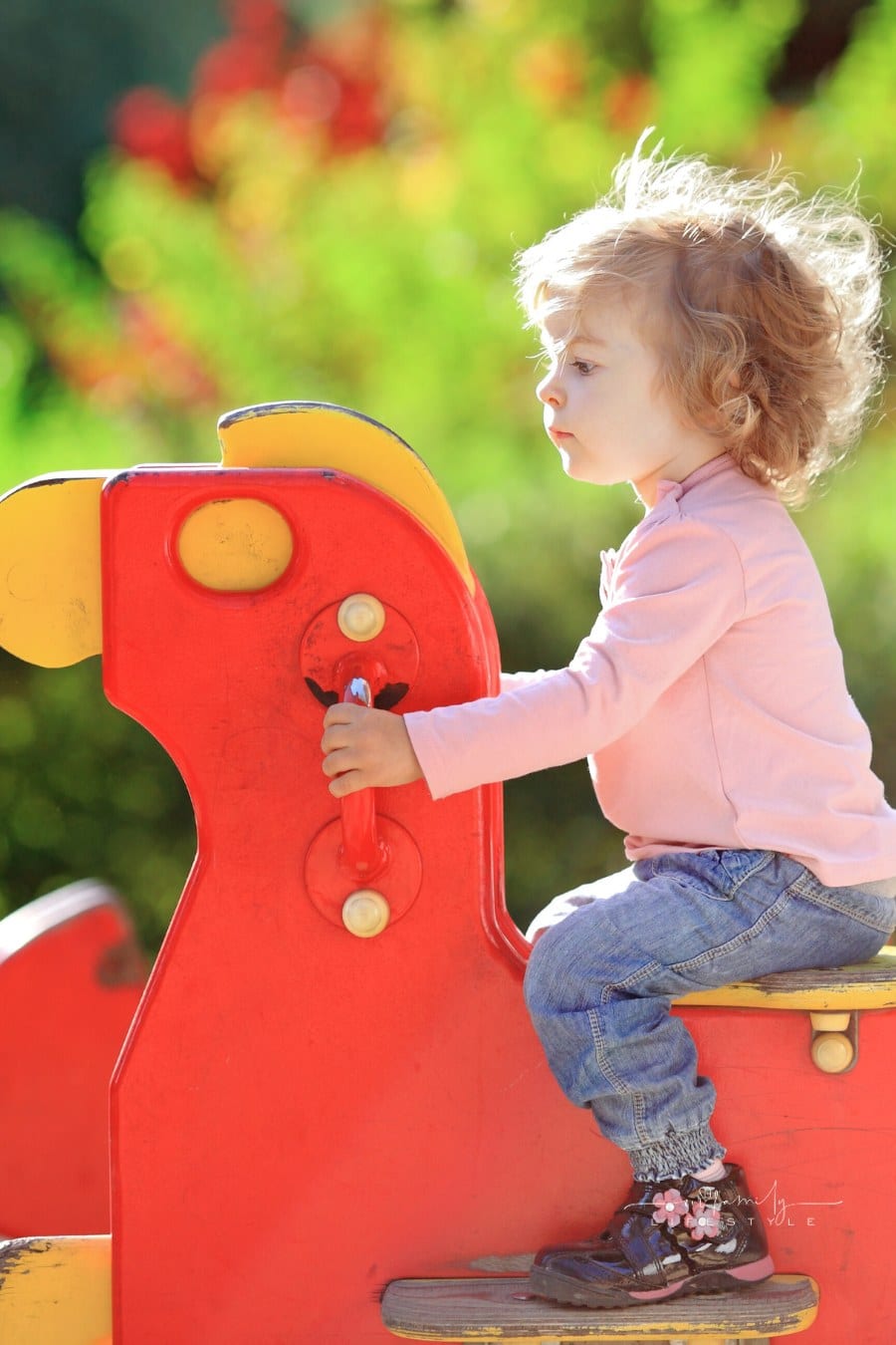 small child on playground rocking horse