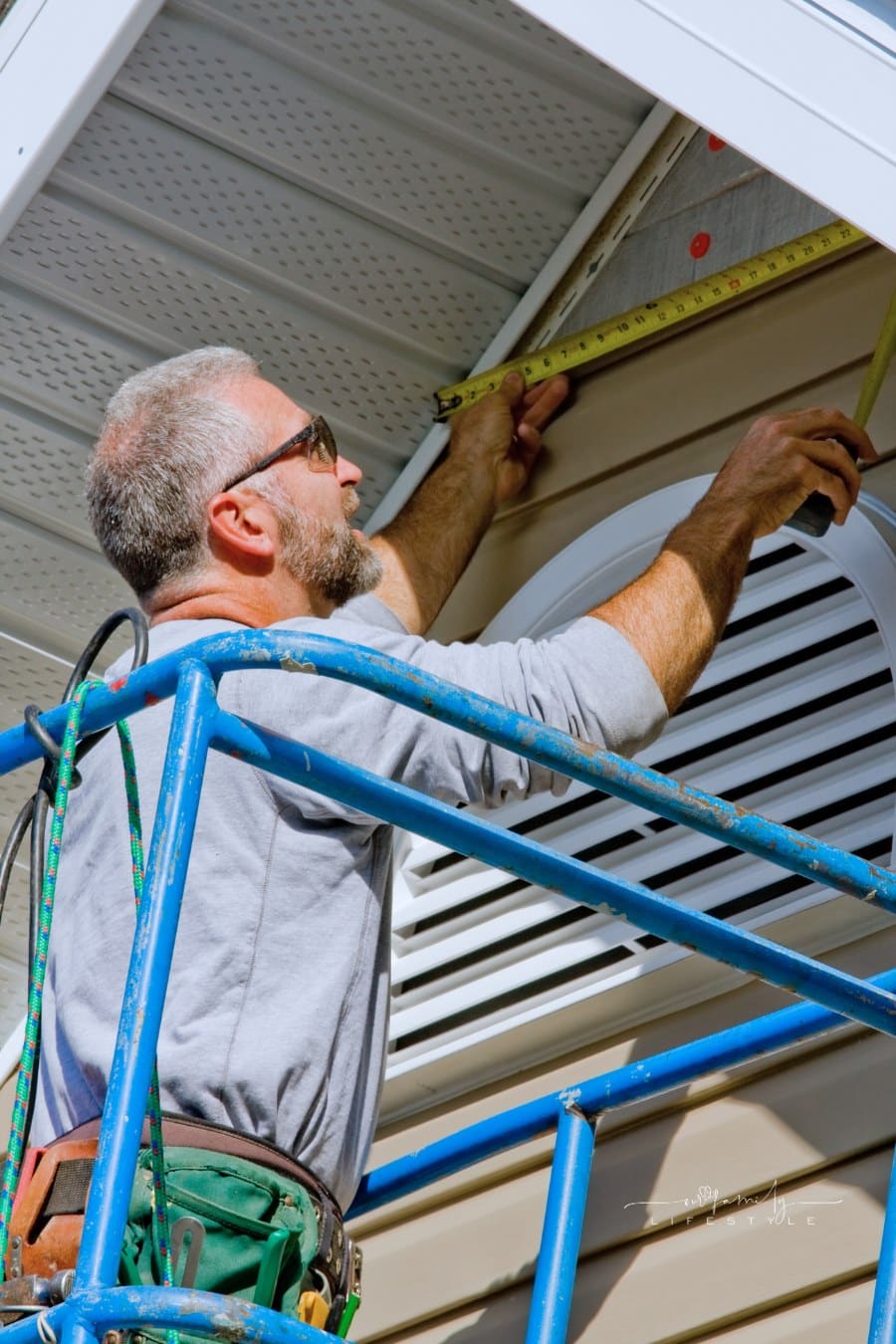 man installing siding on house