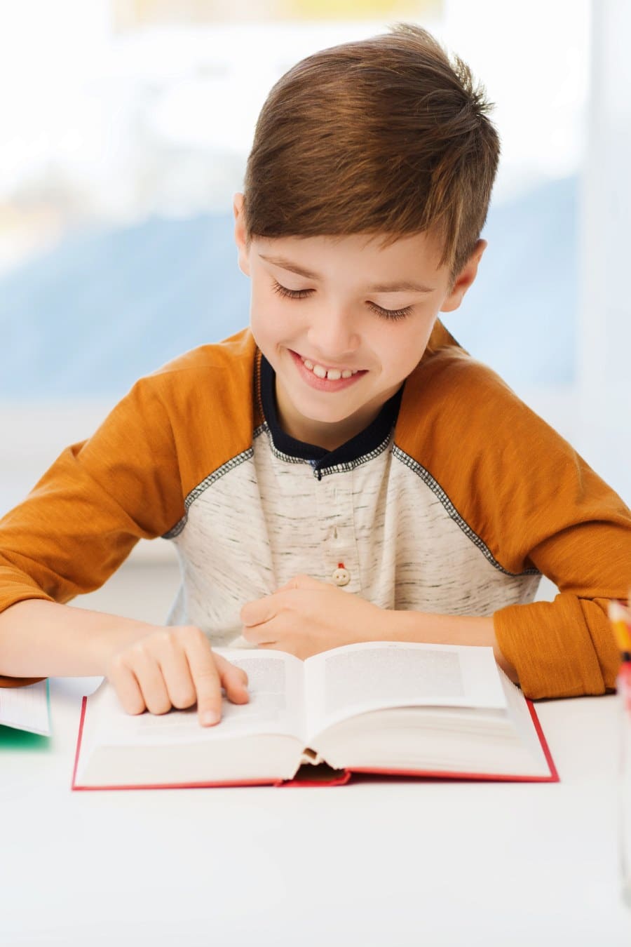 boy reading a book and smiling