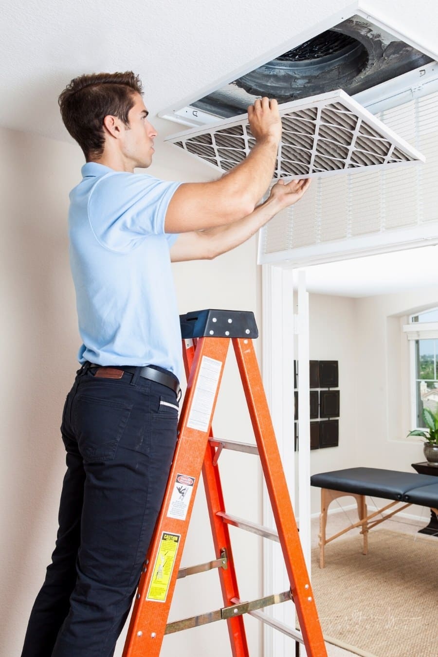 man replacing air filters in HVAC system