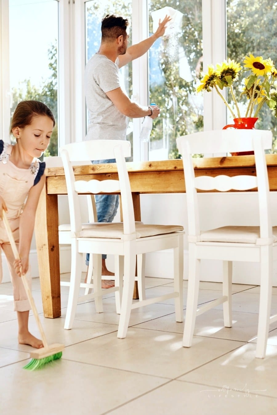 father and daughter cleaning dining room together