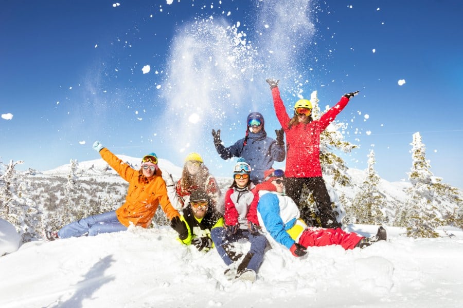 Happy skiers and snowboarders enjoying a winter family trip