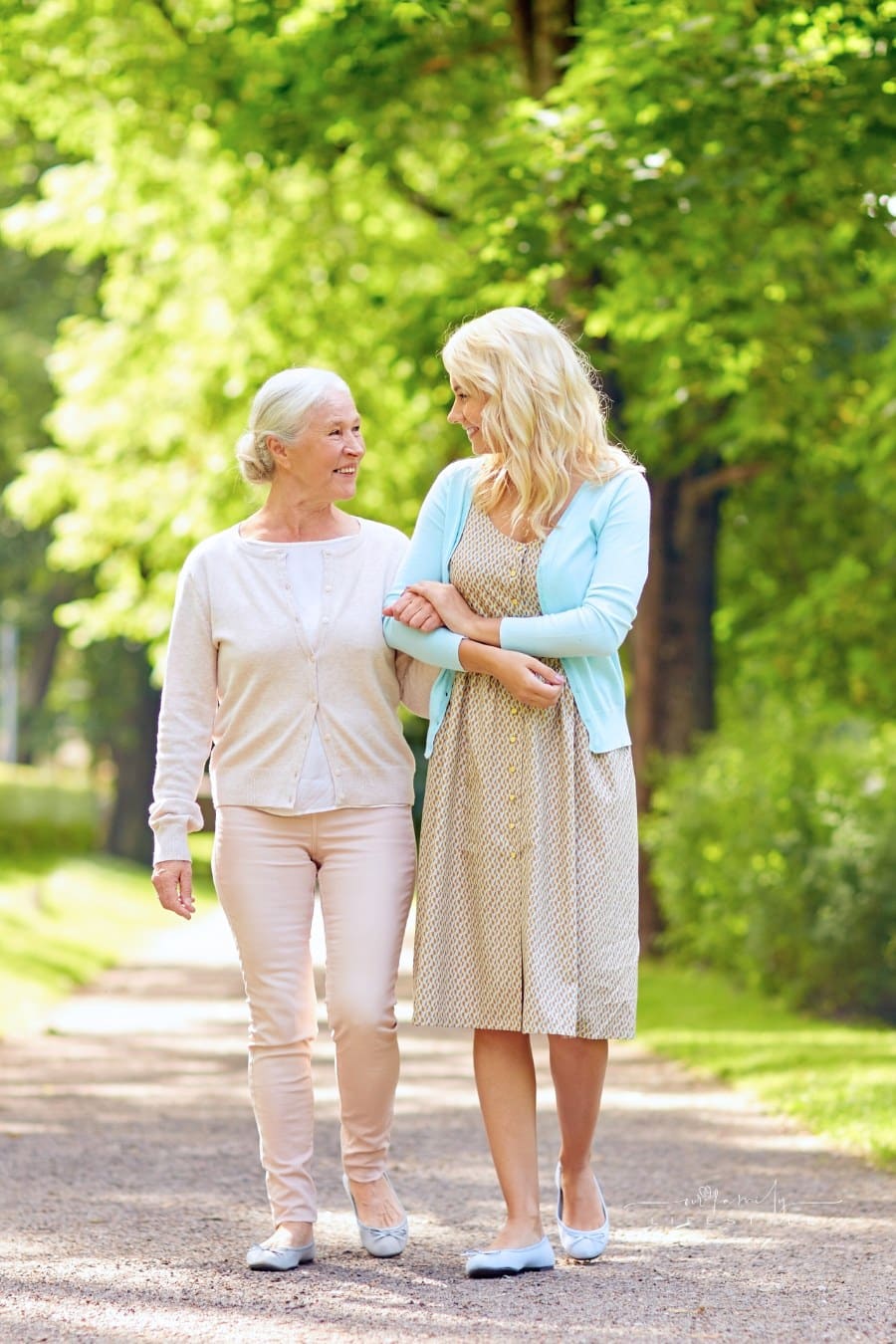 Daughter with Senior Mother Walking at Summer Park