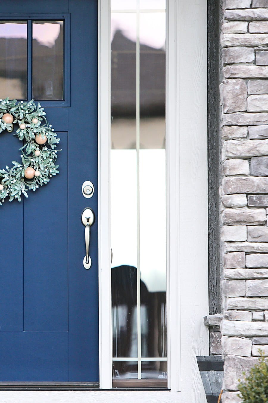 blue front door of grey brick house