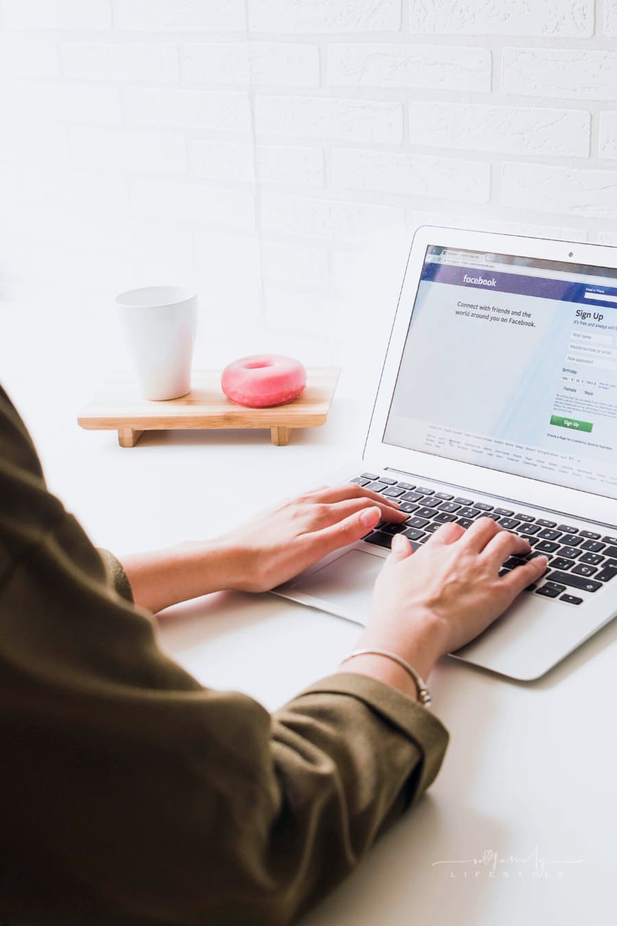 woman logging into Facebook on a laptop