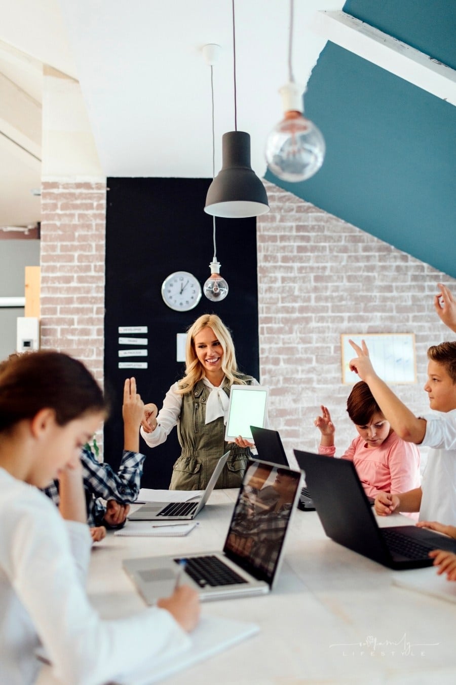 kids sitting at table with laptops learning coding