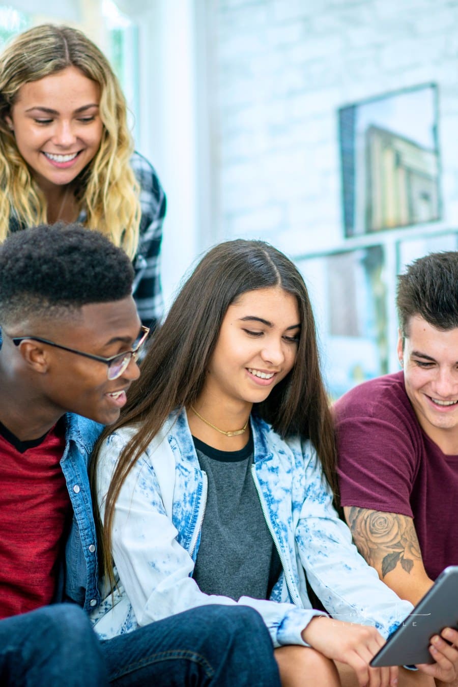 group of teens looking at a tablet together