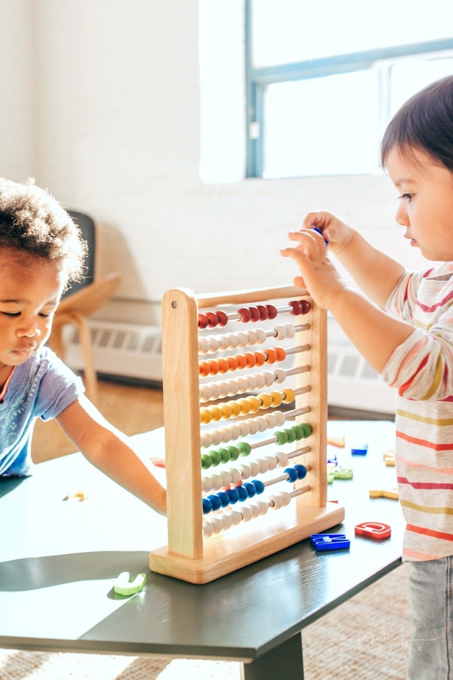 toddler splaying together with a colorful abacus