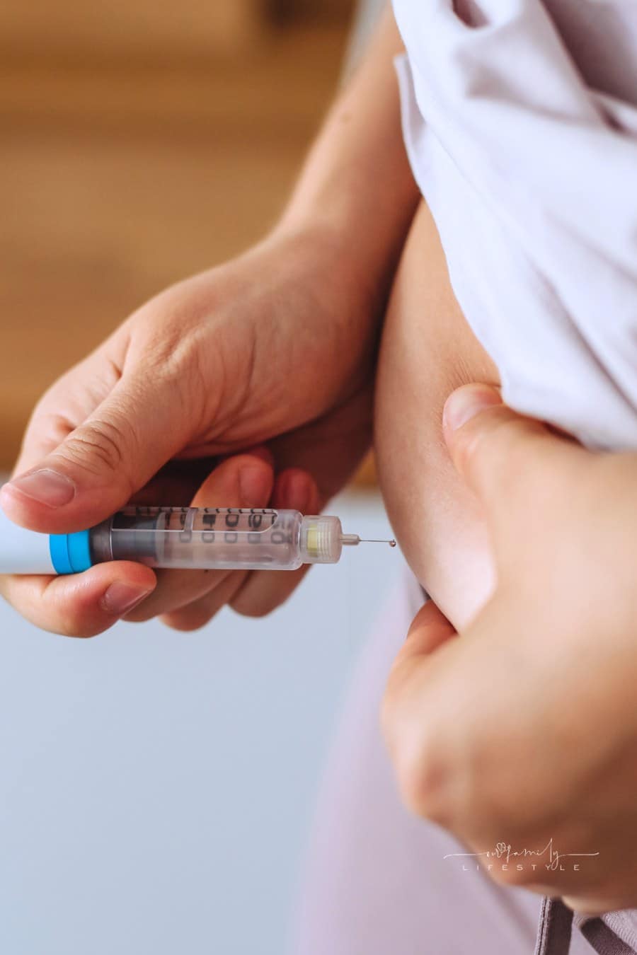 Close-up of Needle Injecting Syringe into Abdomen.
