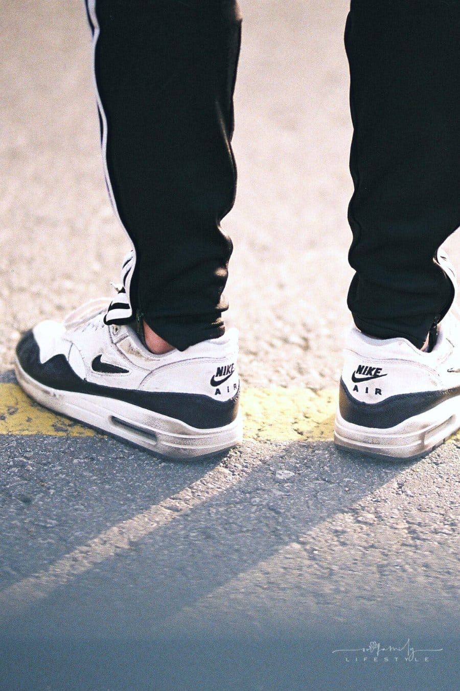 perso wearing black joggers with white and black Nike sneakers