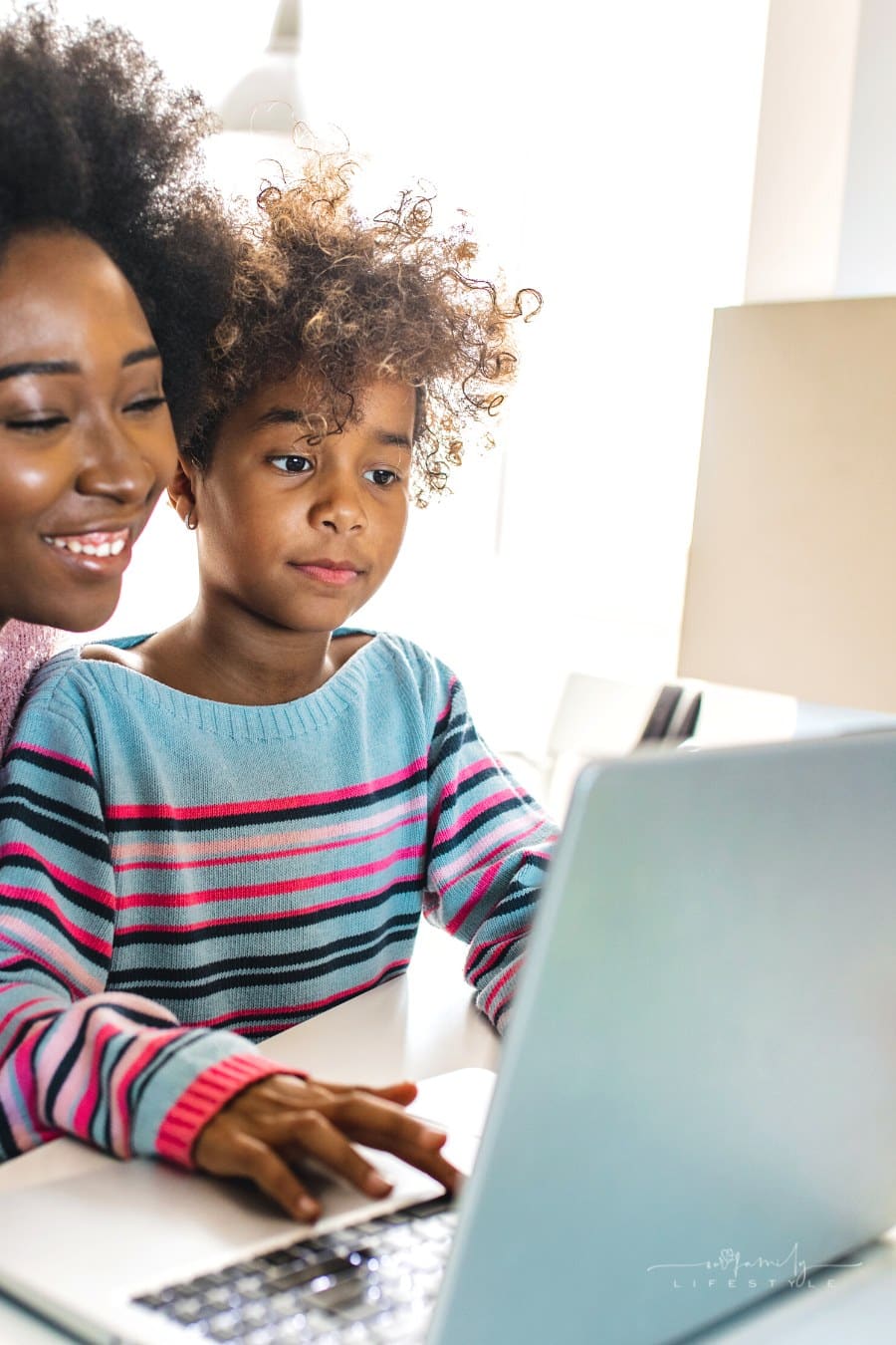 mom helping child learn with laptop at home