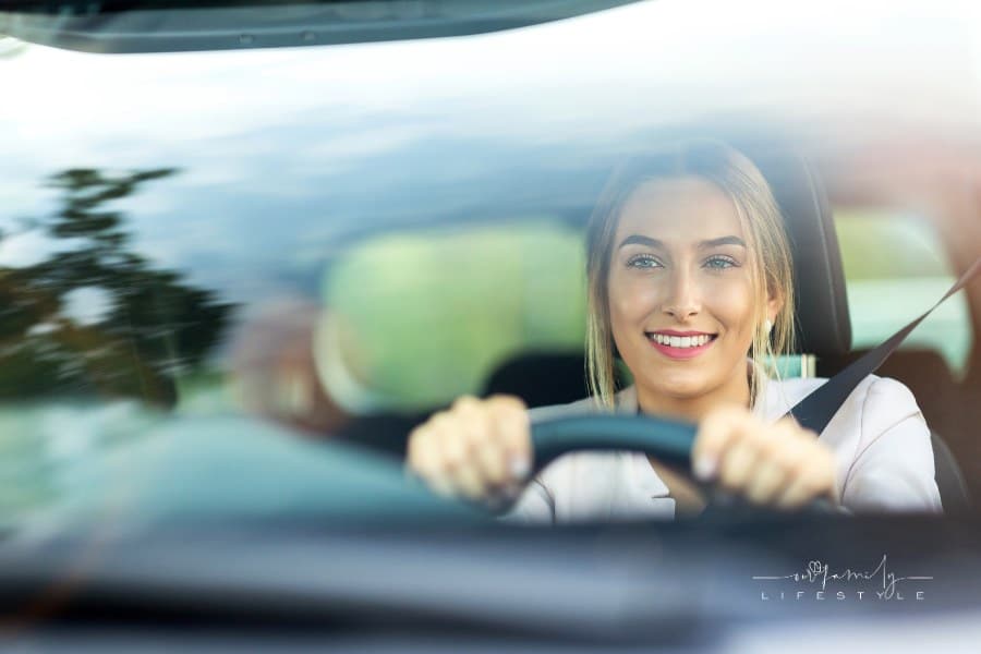 Woman driving a car; view from in front of windshield