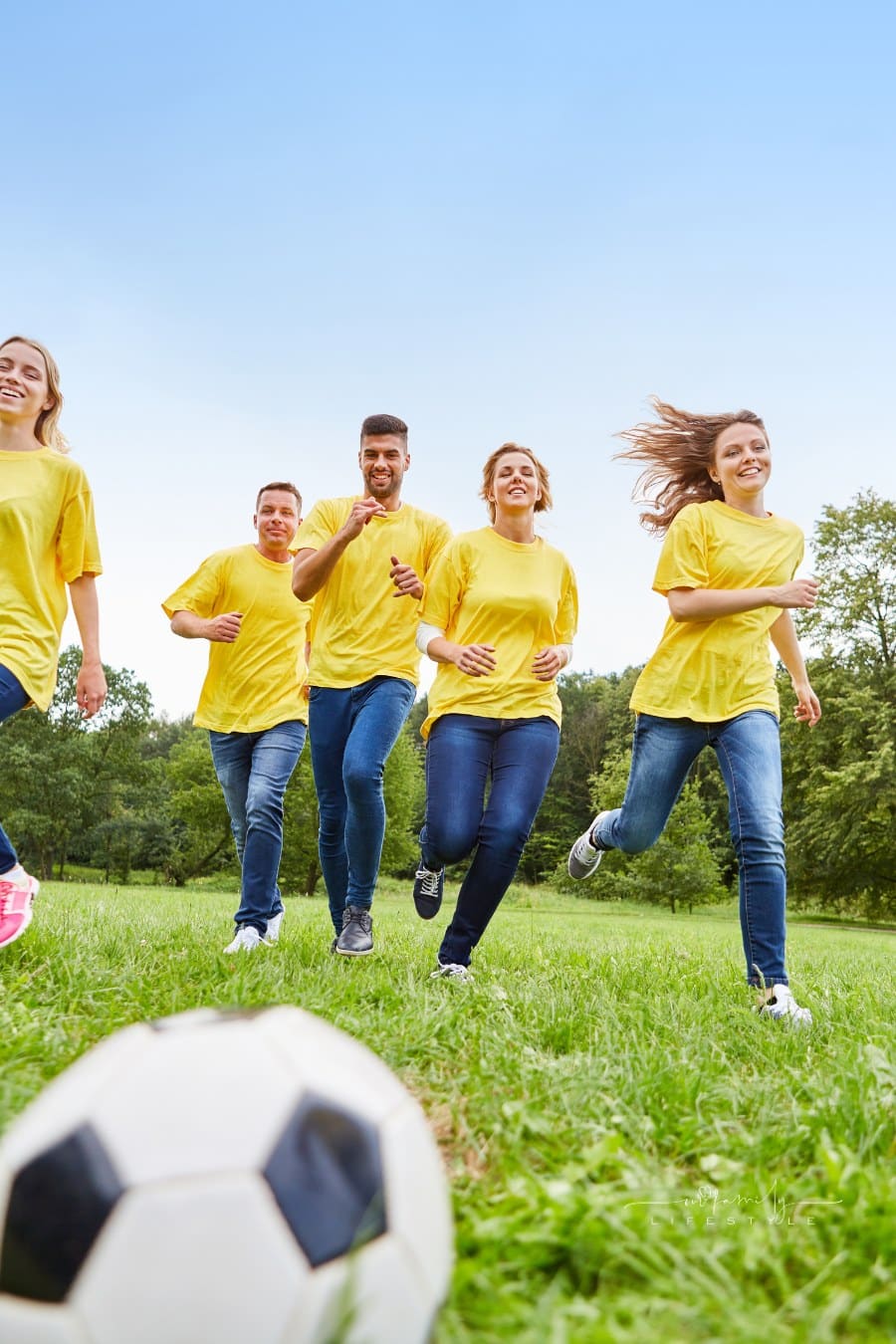 Young People Are Having Fun Playing soccer during field day games event
