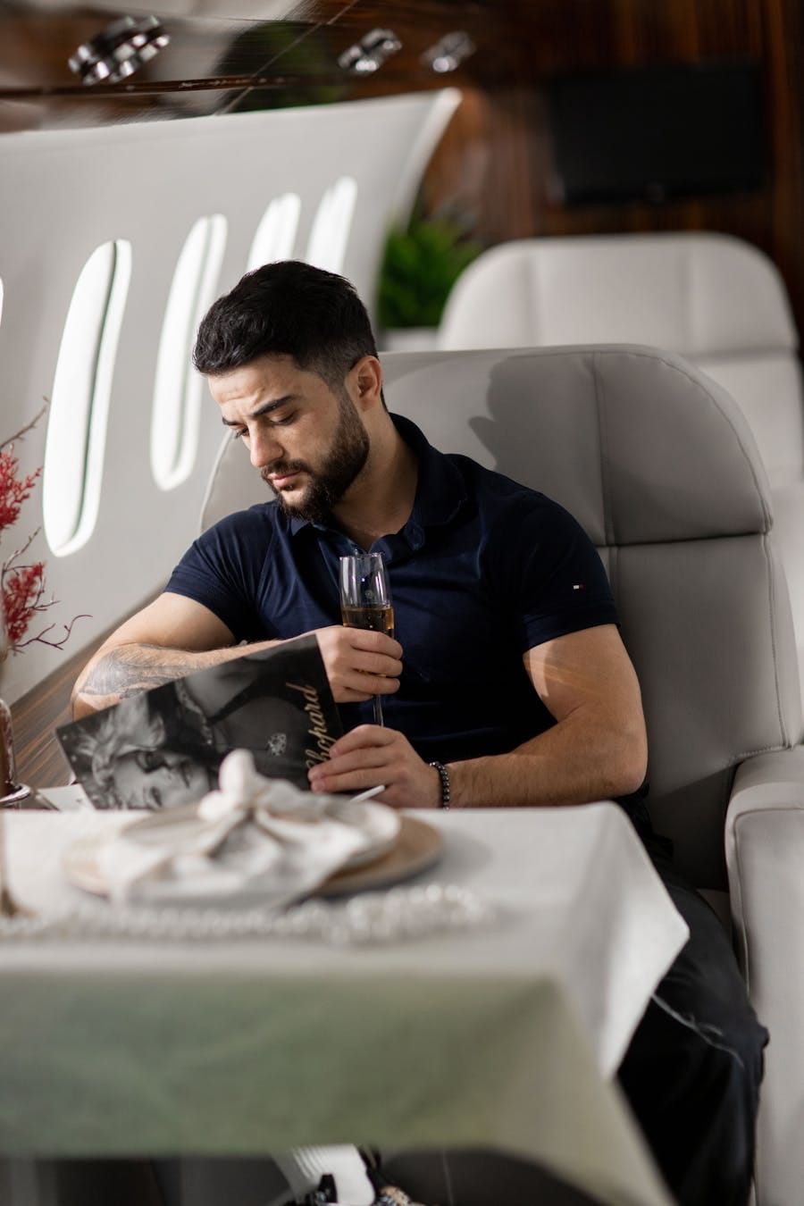 Man enjoying leisure reading with champagne in a private jet.