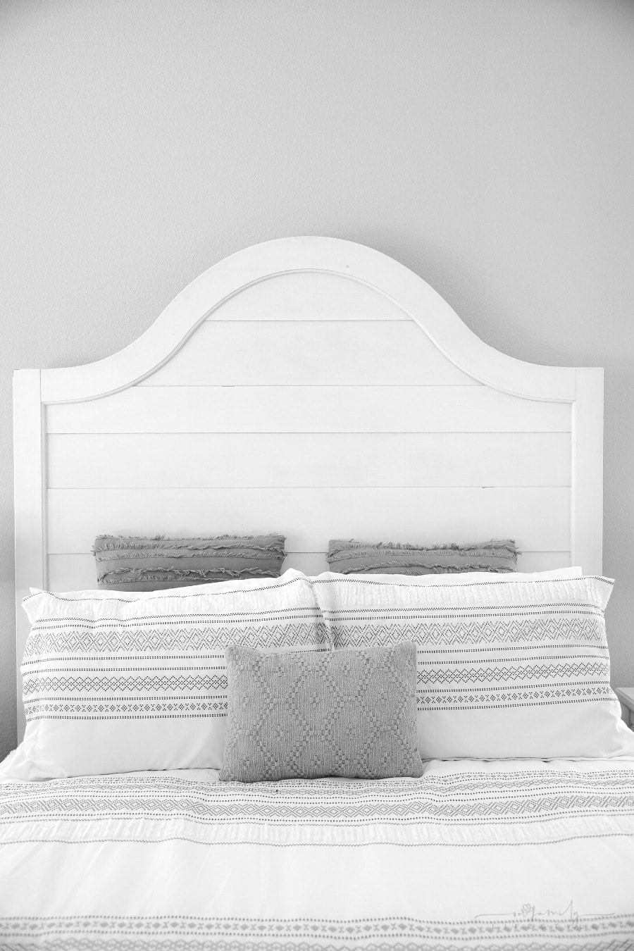 master bedroom with high headboard and gray walls