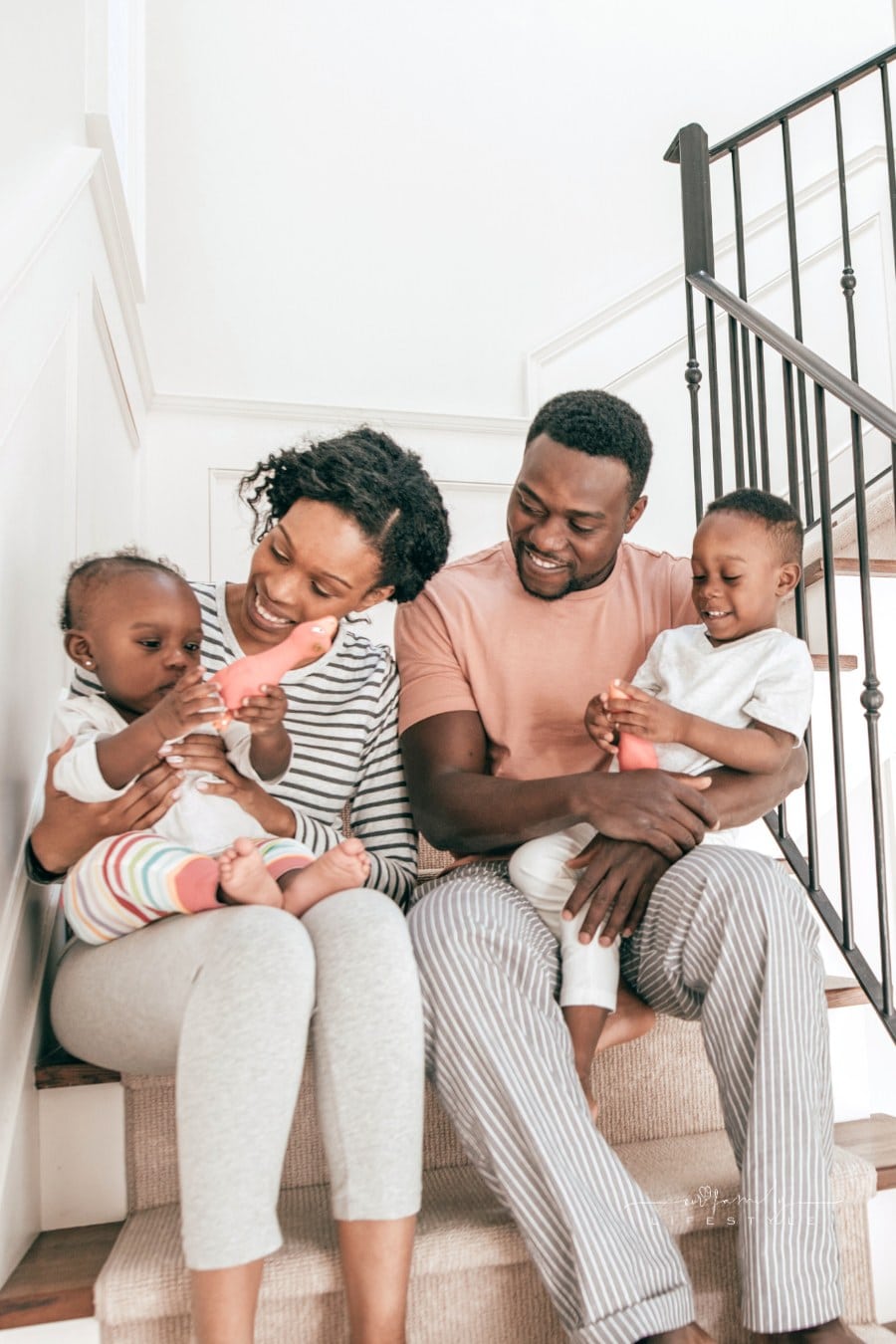 mom and dad sitting on stairs with young children