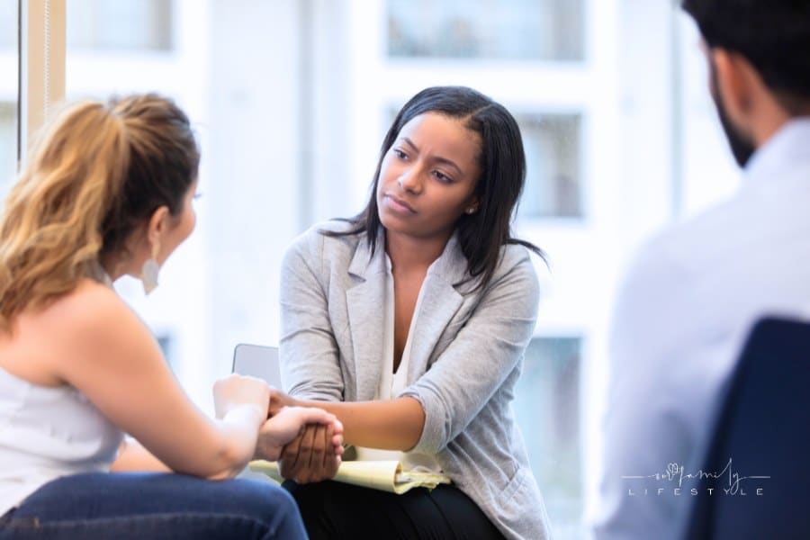 Compassionate counselor listens to client while holding their hand