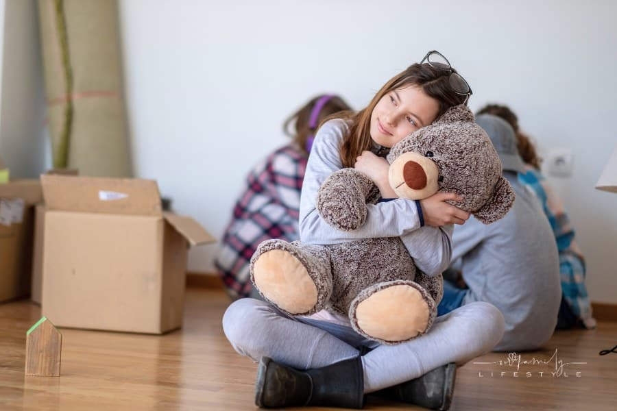 A teenage girl with a teddy bear moving from childhood home