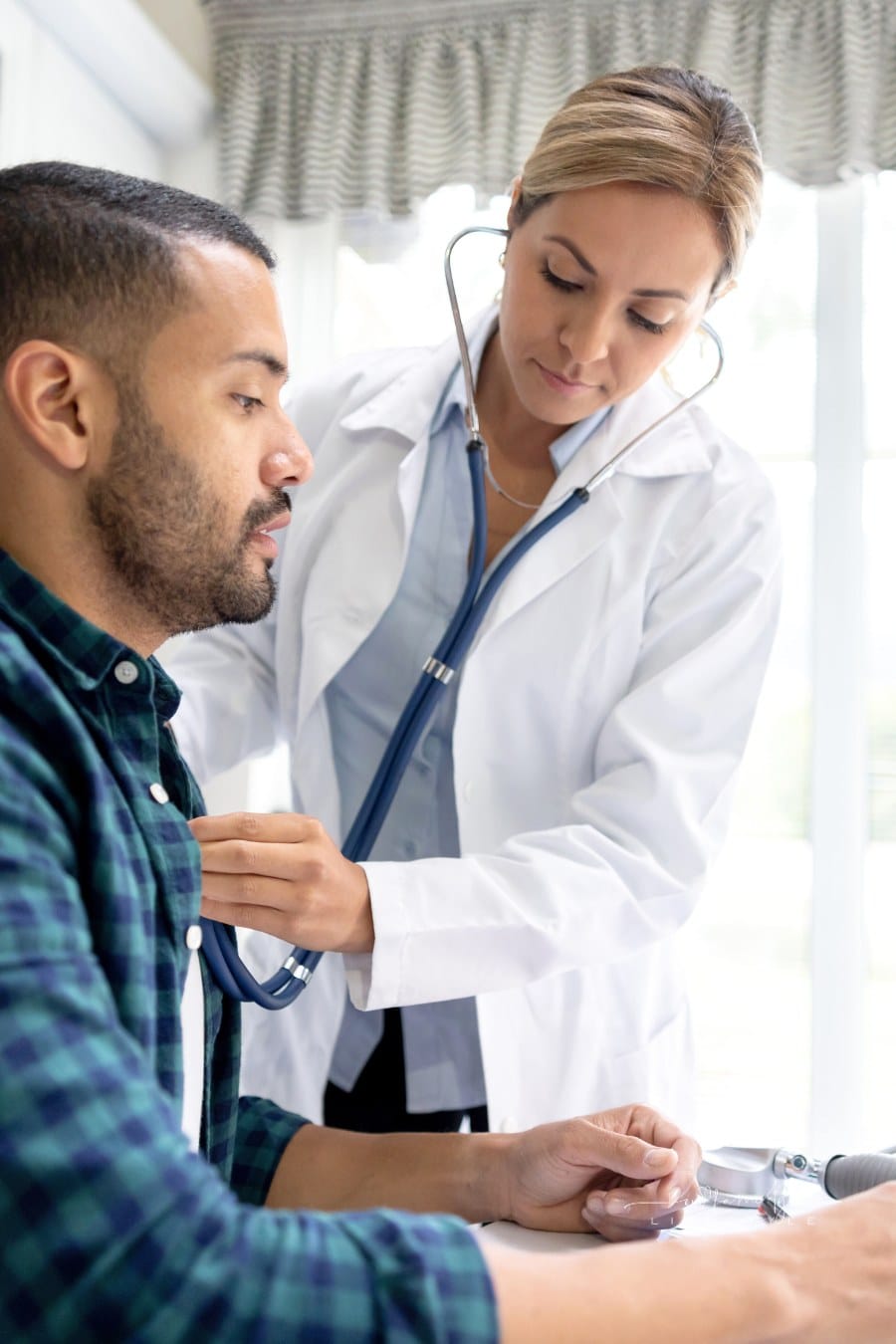 Doctor on a house call performing a medical exam on a patient