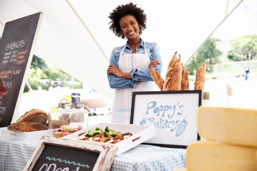 female bakery market stall holder at outdoor market