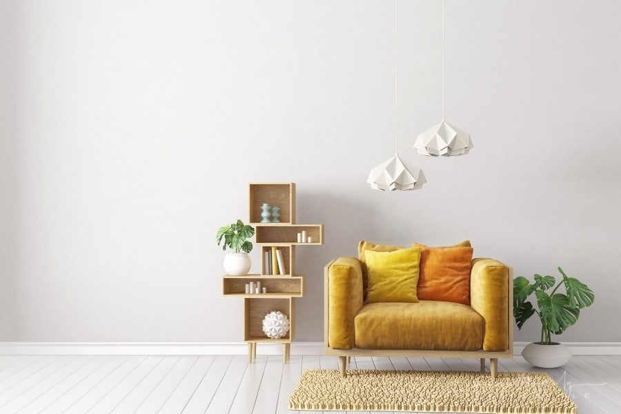 living room with grey wall and white skirting board behind a yellow chair