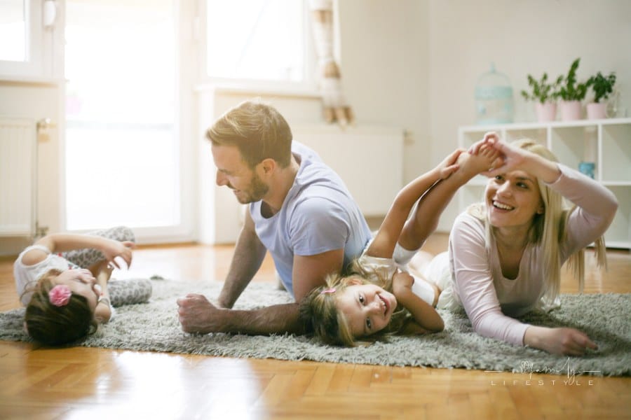 mom and dad playing on the floor with daughters