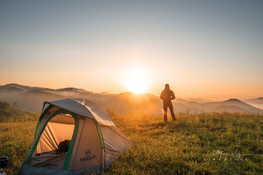 Silhouette of Person Standing Near Camping Tent