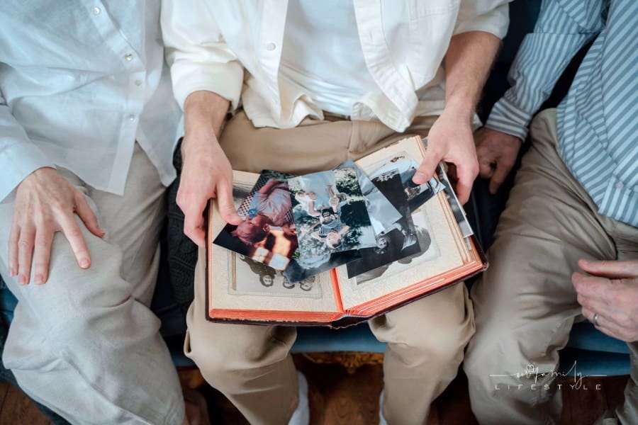 A Family Sitting Together Looking at Old Pictures