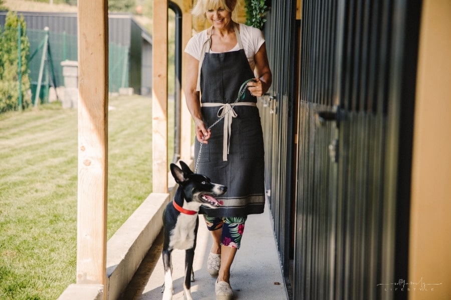 woman smiling while walking dog at boarding home