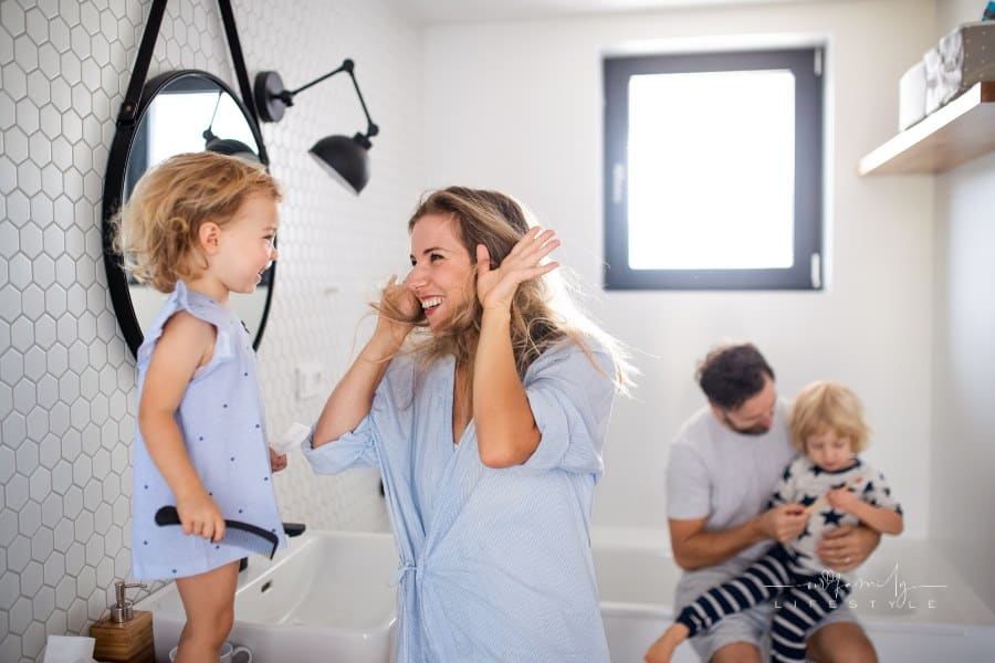 Young Family with Two Small Children Indoors in Bathroom, Having Fun.