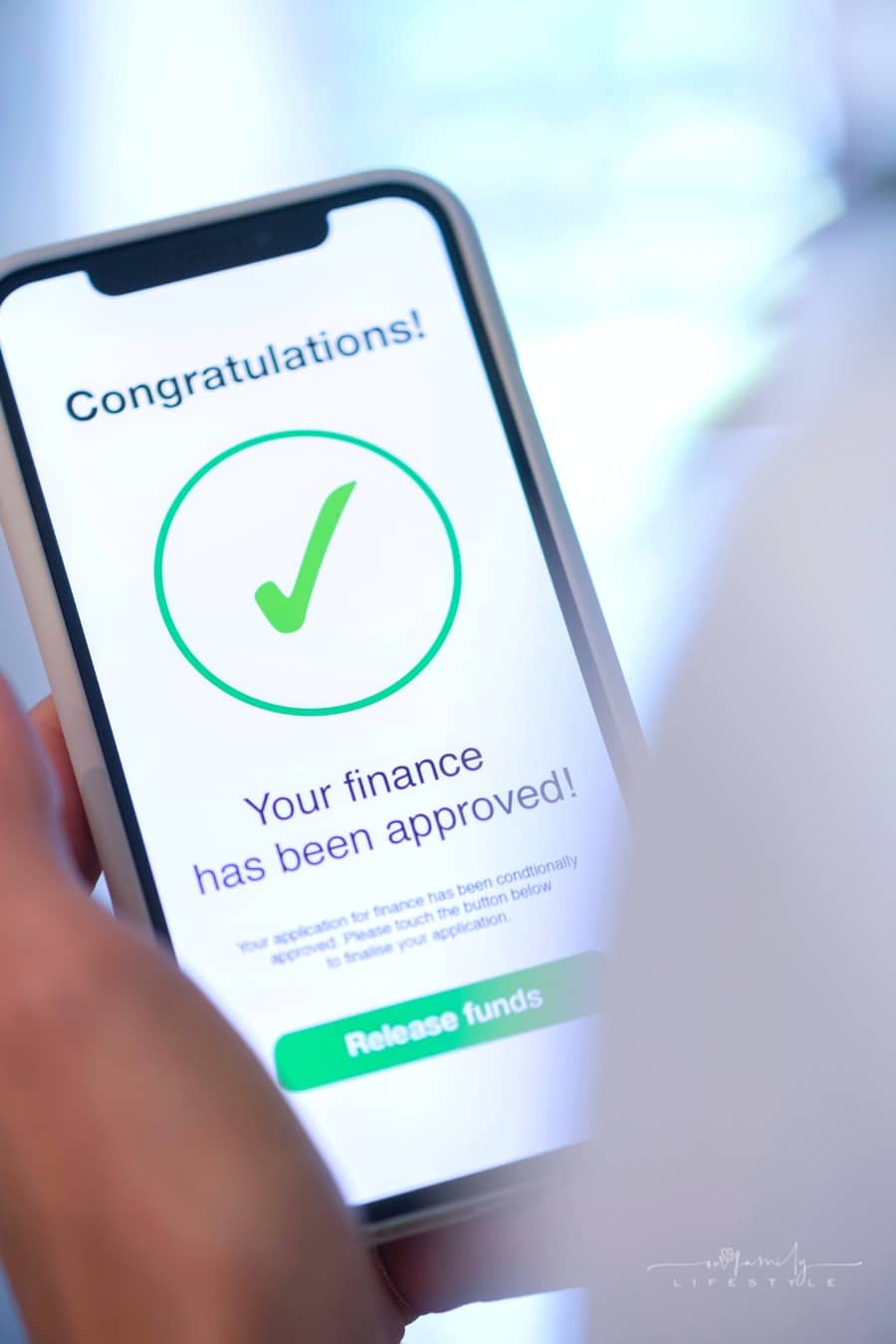 hand holding a mobile phone with loan application approval