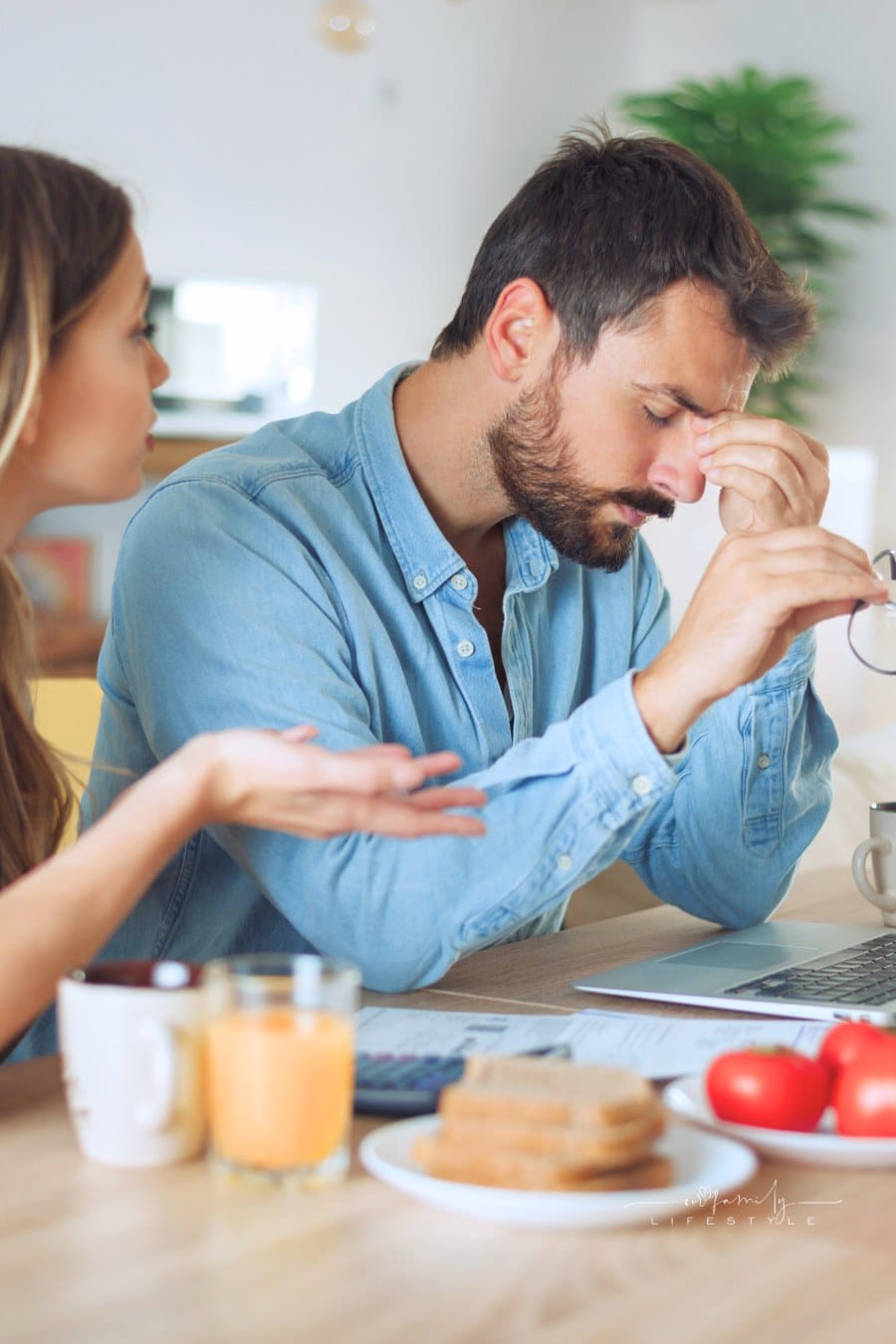 Worried couple arguing while paying bills online at home