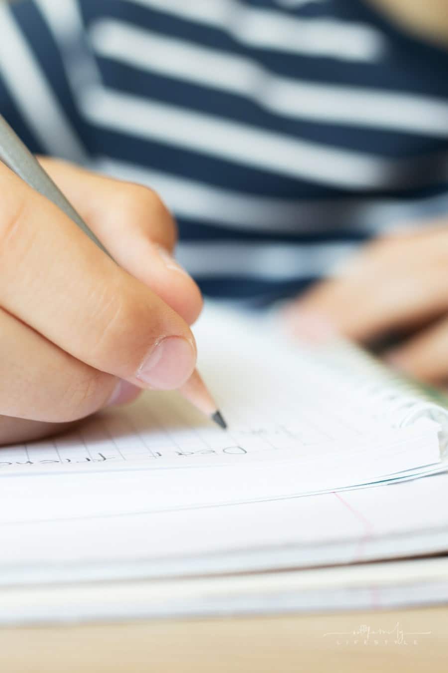 child writing thoughts in a notebook