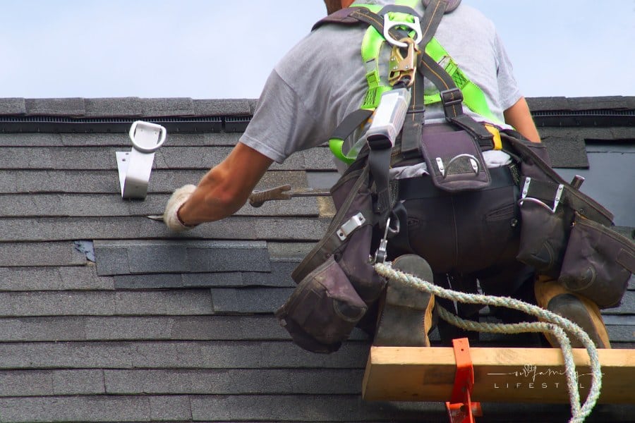 construction worker repairing damaged roof
