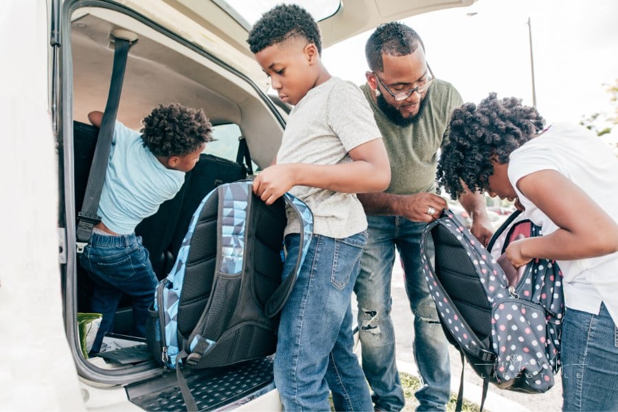 family preparing minivan for a road trip