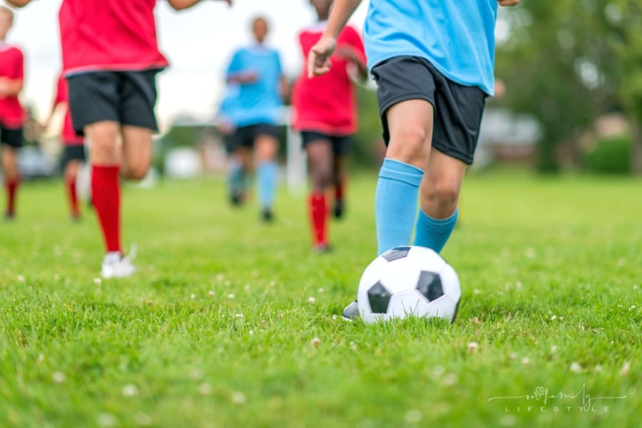 children playing soccer in red and blue uniforms