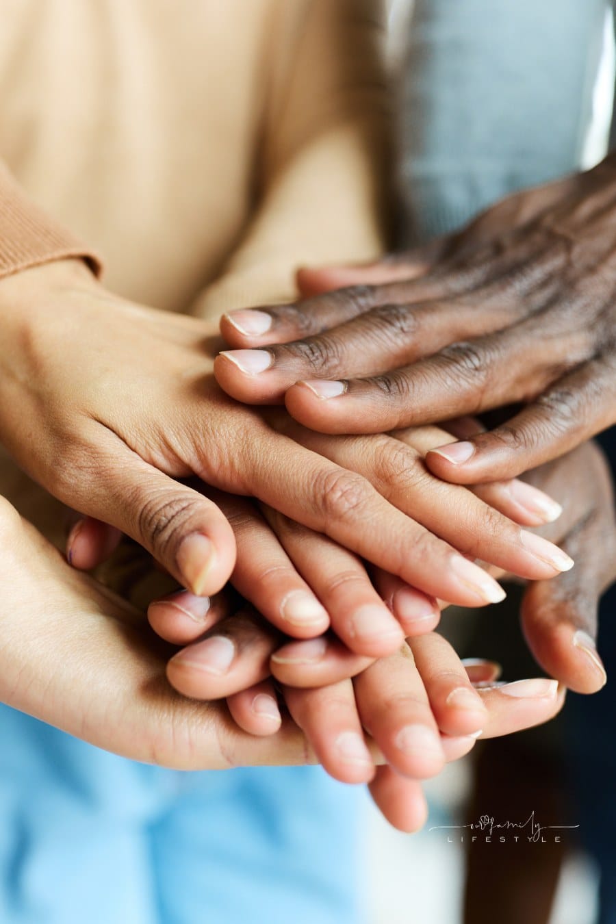 Close up of unrecognizable family gathering their hands together.
