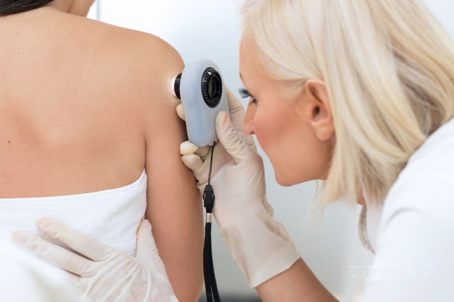 Dermatologist examining patient skin