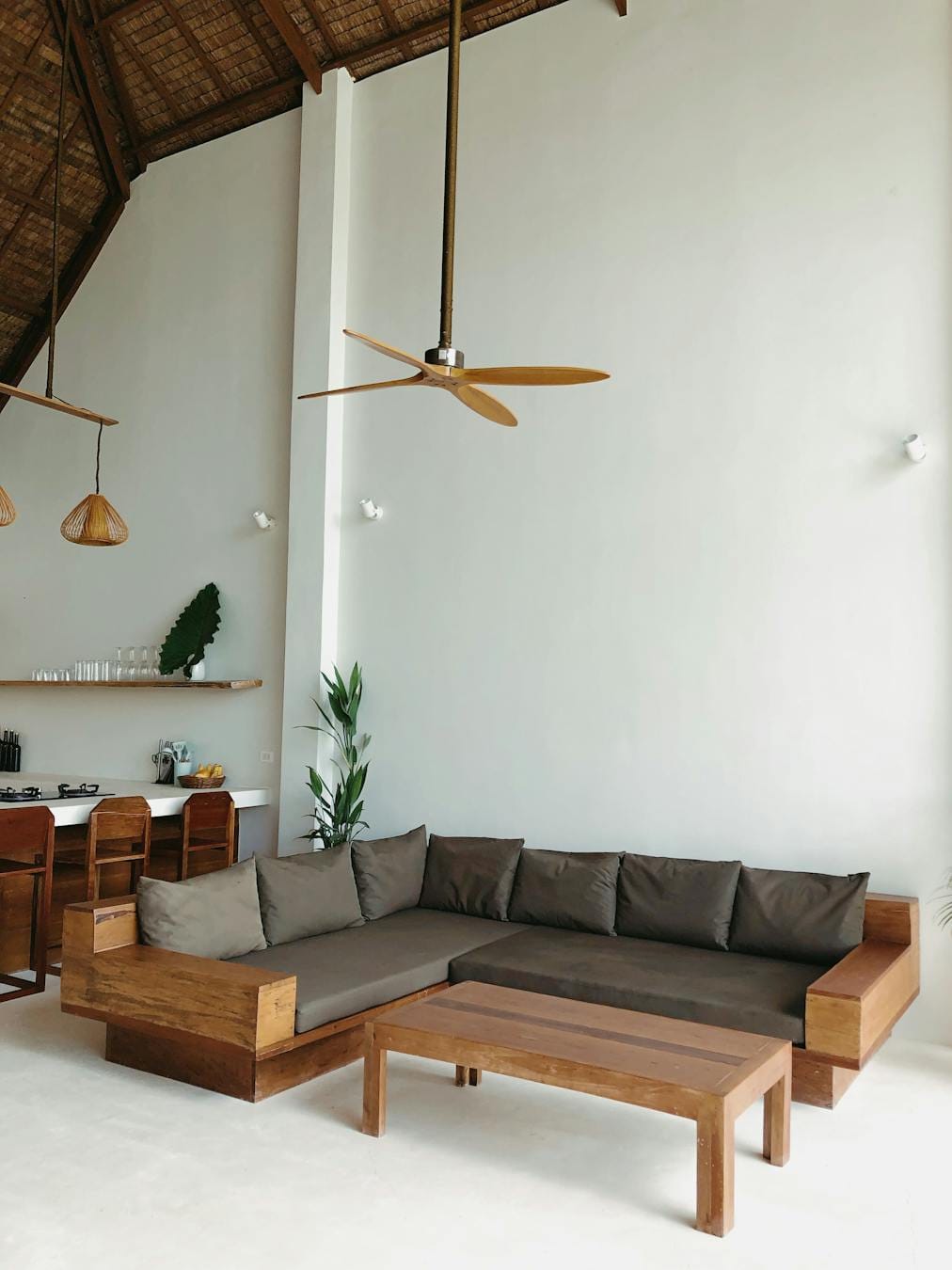 Spacious minimalist living room featuring wooden furniture and neutral tones.