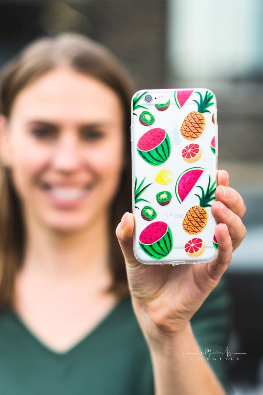 woman holding out custom phone case with watermelon, pineaple, and kiwi design